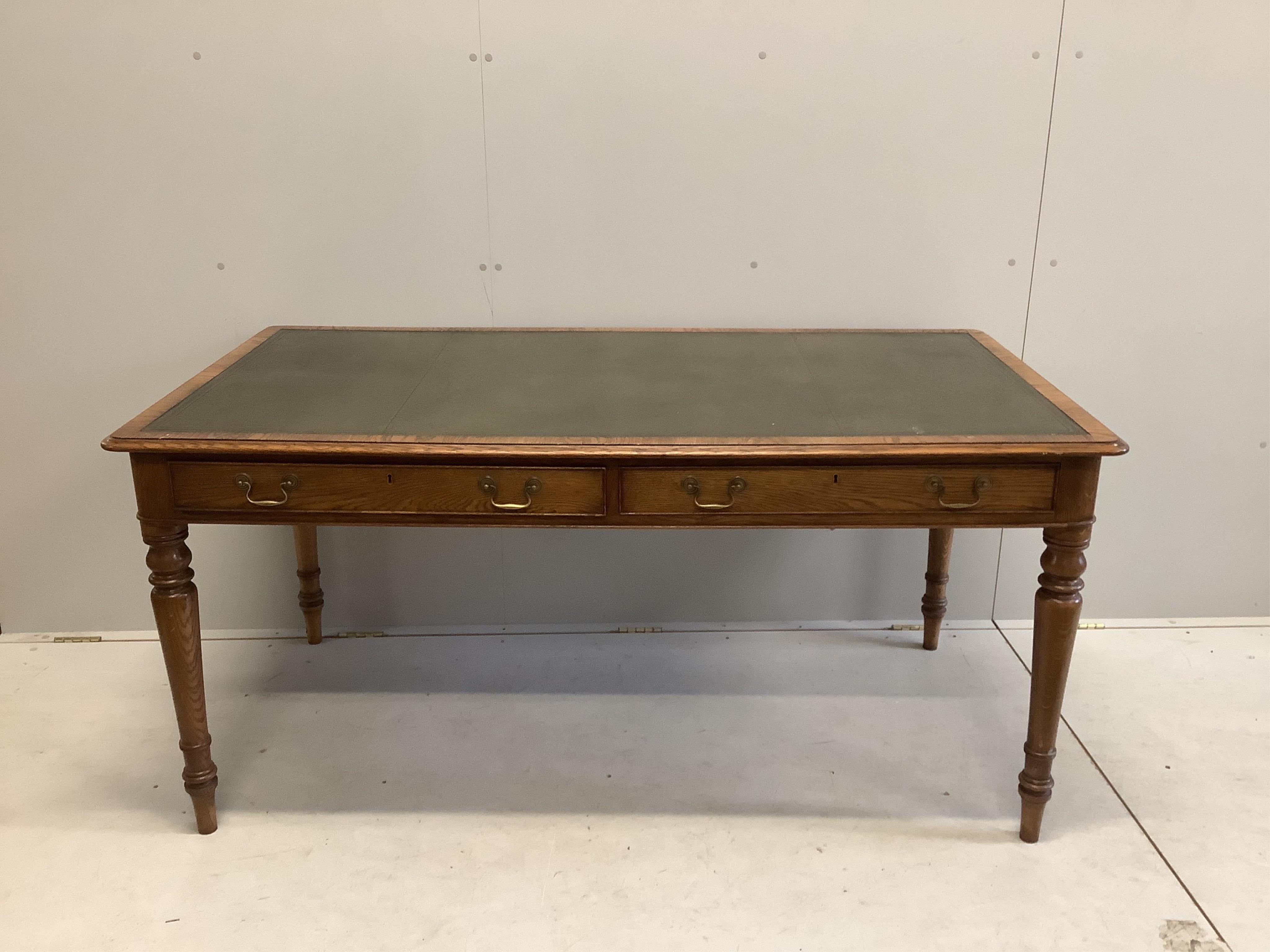 A reproduction Victorian style oak two drawer writing table, width 160cm, depth 84cm, height 76cm. Condition - good